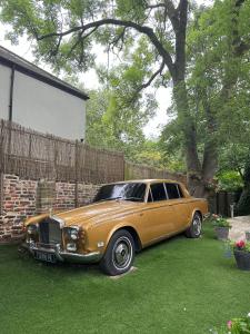 a gold car parked in a yard next to a house at OYO The Townhouse in Durham