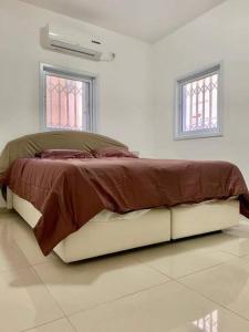 a large bed in a white room with two windows at Family House in Natanya in Netanya