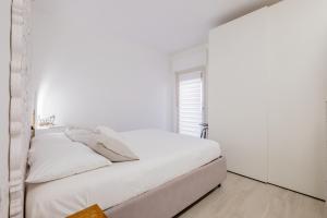 una camera da letto bianca con pareti bianche e un letto di Casa la coccinella a Orbetello