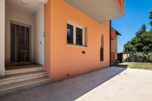 un edificio naranja con escaleras y una ventana en Casa la coccinella, en Orbetello