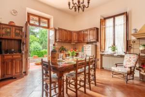 a kitchen with a wooden table and chairs at Villa Lenzi in Lucca