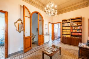 a living room with a chandelier and bookshelves at Villa Lenzi in Lucca