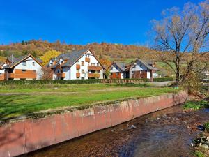a row of houses next to a river at Artur Apartment Myto in Mýto pod Ďumbierom