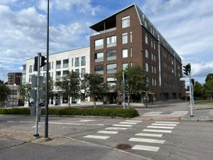 an empty street with a building and a crosswalk at Tyylikäs 35m2 yksiö Hyrylän keskustassa in Hyrylä