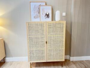 a wicker cabinet with two pictures on top of it at COQUETO APARTAMENTO in Torrelavega +31 photos