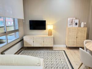 a living room with a flat screen tv and a couch at COQUETO APARTAMENTO in Torrelavega
