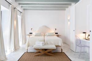 a white bedroom with a bed and a table at Magno Apartments Fabiola 7 Luxury House in Seville