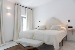 a white bedroom with a large bed with white sheets at Magno Apartments Fabiola 7 Luxury House in Seville