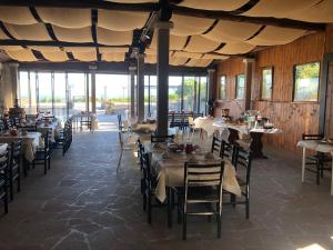 a dining room with tables and chairs and windows at Agriturismo Le Querce in Bomarzo