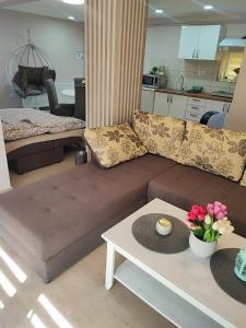 - un salon avec un canapé et une table fleurie dans l'établissement Villa Klaudija, à Petrovaradin