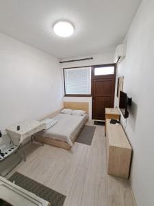 a room with a bed and a desk and a tv at relax in Plovdiv