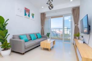 a living room with a couch and a tv at Vung Tau Palm Homestay 1 - Gold Sea in Vung Tau