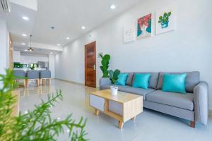 a living room with a blue couch and a table at Vung Tau Palm Homestay 1 - Gold Sea in Vung Tau