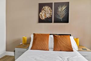 a bedroom with a white bed with two orange pillows at Stylish Great Location Near Tamar Bridge in Saltash