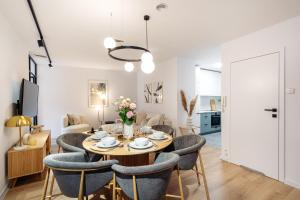 a dining room and living room with a table and chairs at Piedmont Apartments by LoftAffair in Krakow