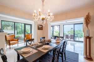 a dining room with a table and chairs and a chandelier at Homie Suites - 3br villa w pool in Heybeliada in Adalar