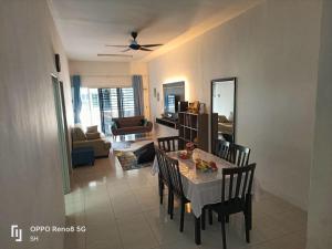 a dining room with a table and chairs and a living room at Homestay Jerantut Sincerelyat in Jerantut