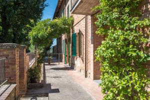 eine Gasse mit einem Backsteingebäude mit grünen Rollläden in der Unterkunft Podere San Lorenzo in Siena