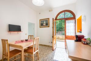 ein Esszimmer mit einem Tisch, Stühlen und einem Fenster in der Unterkunft Podere San Lorenzo in Siena
