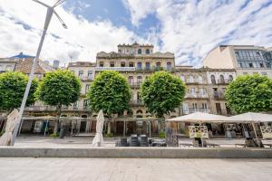 un grande edificio con tavoli e ombrelloni di fronte di Vistas al Nautico y Paseo Marítimo de Vigo a Vigo