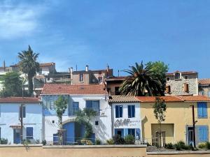 a group of buildings with palm trees in the background at Maison Bon Ton in Paraza