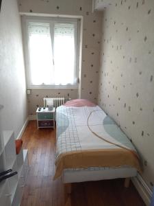 Habitación pequeña con cama y ventana en Petite chambre meublée au cœur de ville - chez l'habitant, en Le Creusot