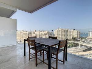 Five Palm Hotel and Residence - Platinium Dubai في دبي: طاولة وكراسي على شرفة مطلة على مدينة