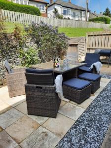 a patio with a table and wicker chairs at Coddiwomple in Leyburn