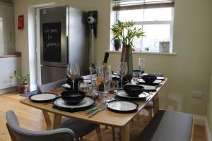 a wooden table with plates and wine glasses on it at Coddiwomple in Leyburn