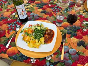 una mesa con un plato de comida y una botella de vino en Maison Bon Ton, en Paraza