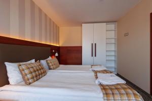 1 dormitorio con 2 camas y armario blanco en Ruskovets Thermal SPA & Ski Resort en Bansko