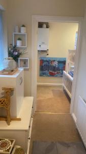 a childs room with a hallway with a crib and a refrigerator at Lovely 2 bed apartment sleeps 5 in Abingdon +4 photos