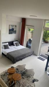 1 dormitorio con 1 cama y 2 mesas. en Canal Garden Apartment StayWell Amsterdam, en Ámsterdam