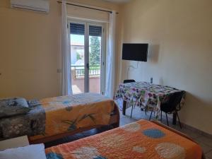 a room with two beds and a table and a window at Nuovaiegi in Isola Capo Rizzuto