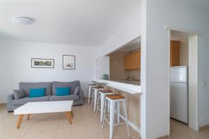 a living room with a couch and a kitchen at Apartamentos Elena in Puerto del Carmen