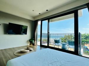 Schlafzimmer mit einem Bett und einem Balkon mit einem TV in der Unterkunft 厝True Hub旅店 in Nanwan
