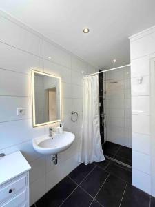 a white bathroom with a sink and a mirror at Stilvolles Apartment nahe Therme und PreZero Arena in Sinsheim