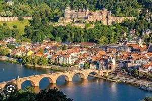a bridge over a river with a city and a castle at Stilvolles Apartment nahe Therme und PreZero Arena in Sinsheim