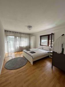 ein Schlafzimmer mit einem großen Bett und Holzboden in der Unterkunft Stilvolles Apartment nahe Therme und PreZero Arena in Sinsheim
