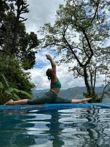 Kāskī的住宿－Into The Wild Pokhara，一名在游泳池边做瑜伽的女人