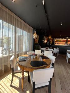 une salle à manger avec une table en bois et des chaises blanches dans l'établissement Hotel Azur, au Coq