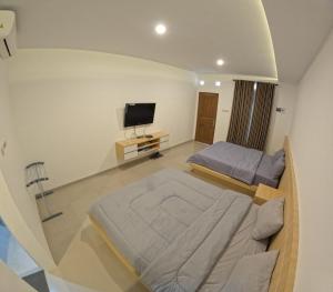 Habitación grande con cama y TV. en Joglo Riverside, en Kejayan