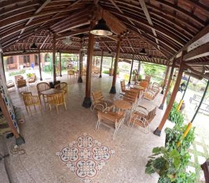 un pabellón con mesas, sillas y mesas y sillas en Joglo Riverside, en Kejayan