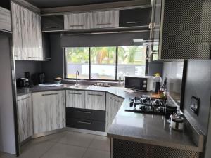 cocina con fregadero y fogones horno superior en Umhlanga Guesthouse flat, en Durban
