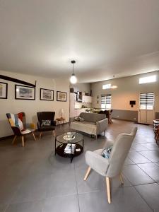 a living room with chairs and a couch and a table at Séjour au vert in Vert