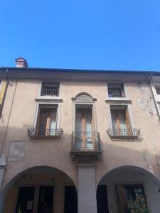 a building with windows and balconies on a street at Attico96 Intero appartamento in centro storico in Marostica