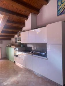 a large kitchen with white cabinets and a wooden ceiling at Attico96 Intero appartamento in centro storico in Marostica