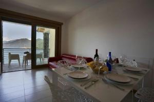 una mesa de comedor con copas de vino y botellas de vino. en Residence degli Oleandri 6A, en Argegno