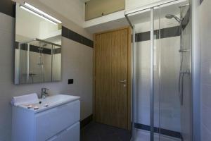 a bathroom with a sink and a shower with a mirror at Residence degli Oleandri 6A in Argegno