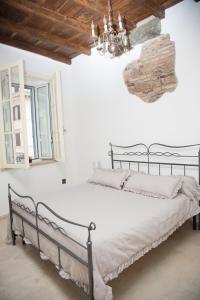 een bed in een witte kamer met een kroonluchter bij Casa vacanza Colosseo 2 in Rome